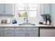 Close up of modern kitchen featuring light blue cabinets, white subway tile backsplash, and stainless steel faucet at 700 Preservation Pl, Mount Pleasant, SC 29464