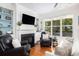 Cozy living room with a fireplace, built-in shelves, hardwood floors, and ample natural light at 700 Preservation Pl, Mount Pleasant, SC 29464