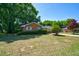 Inviting single-story brick home with a well-manicured lawn and mature trees on a sunny day at 779 Dills Bluff Rd, Charleston, SC 29412