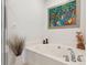 Modern bathroom with a jacuzzi tub, tropical artwork and an ornate faucet at 81 Sandbar Ln # 19, Folly Beach, SC 29439