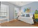 Coastal bedroom featuring a daybed with blue pillows, beach-themed art, and a surfboard at 81 Sandbar Ln # 19, Folly Beach, SC 29439