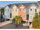 Charming multi-colored townhomes with palm trees, covered parking, and convenient stair access to each unit at 81 Sandbar Ln # 19, Folly Beach, SC 29439