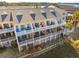 Rear exterior of a multi-story townhouse with balconies and waterviews at 81 Sandbar Ln # 19, Folly Beach, SC 29439