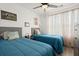 Bright bedroom featuring twin beds, a ceiling fan, and natural light streaming through sheer curtains at 9105 Parlor Dr, Ladson, SC 29456