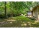 Green backyard with an enclosed back porch and mature trees providing shade at 10 Skyeman Dr, Charleston, SC 29414
