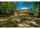 Spacious backyard featuring a brick house with many windows, set among mature trees, offering both privacy and natural beauty at 100 Colonial Dr, Goose Creek, SC 29445