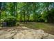 Secluded backyard with mature trees and a concrete patio, ideal for relaxing and enjoying the outdoors at 100 Colonial Dr, Goose Creek, SC 29445