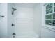 Bright bathroom featuring tiled walls, a window, and a shower with black fixtures at 100 Colonial Dr, Goose Creek, SC 29445
