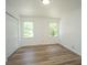Bright, minimalist bedroom with wood floors, white walls, two windows and double closet doors, showcasing clean lines at 100 Colonial Dr, Goose Creek, SC 29445