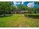 Traditional brick home with manicured lawn, mature trees, and a charming front yard fountain adding to its curb appeal at 100 Colonial Dr, Goose Creek, SC 29445