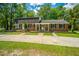 Traditional brick home with a manicured lawn and mature trees at 100 Colonial Dr, Goose Creek, SC 29445