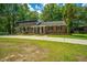 Charming brick home with a manicured lawn, surrounded by lush trees and greenery at 100 Colonial Dr, Goose Creek, SC 29445