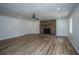 Open living room with wood-look floors and a classic brick fireplace at 100 Colonial Dr, Goose Creek, SC 29445