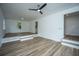 Bright living room featuring hardwood floors, ceiling fan, and a step-up platform area with natural light at 100 Colonial Dr, Goose Creek, SC 29445