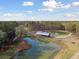 Breathtaking aerial view of a community pond with a wooden bridge and surrounding landscape at 1013 Sagegrass St, Summerville, SC 29485