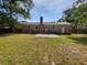 View of the backyard of a brick home with a concrete patio and lush green grass at 102 Rebellion Rd, Summerville, SC 29483