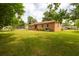 Expansive backyard with lush greenery surrounding a charming brick home at 104 Belmont Ct, Ladson, SC 29456