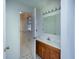 Bathroom featuring a tiled shower with safety bars, wood cabinet, and an open doorway at 104 Belmont Ct, Ladson, SC 29456