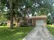Attractive single-story brick home with a garage and accessible ramp, nestled under a mature tree canopy at 104 Belmont Ct, Ladson, SC 29456