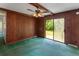 Cozy living room featuring wood paneling, ceiling fan, and sliding glass doors to the backyard at 104 Belmont Ct, Ladson, SC 29456