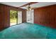 Cozy living room featuring wood paneling, ceiling fan, and sliding glass doors to the backyard at 104 Belmont Ct, Ladson, SC 29456
