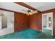 Living room featuring wood paneling, beamed ceiling, ceiling fan, and doorway to kitchen at 104 Belmont Ct, Ladson, SC 29456