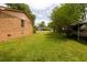 Side yard featuring green grass and the brick house in the background at 104 Belmont Ct, Ladson, SC 29456