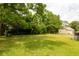 Lush green yard featuring mature trees and a charming house at 104 Belmont Ct, Ladson, SC 29456