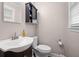 This half-bathroom features a toilet, sink, mirror, and a small storage unit above the toilet at 104 Greensboro Ln, Ladson, SC 29456