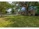 Single-story home with a covered front porch, brick accents, and a large shade tree at 104 Greensboro Ln, Ladson, SC 29456