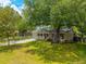 Single-story home with a welcoming front porch, well-kept lawn, and mature shade trees at 104 Greensboro Ln, Ladson, SC 29456