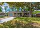 Single story home with a welcoming front porch, well-kept lawn, and mature trees at 104 Greensboro Ln, Ladson, SC 29456