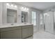 Bright bathroom featuring double vanity with grey cabinets and large glass-enclosed shower at 1059 Sago Palm Ct, Mount Pleasant, SC 29429