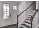 Bright foyer featuring a staircase, hardwood floors, and a front door with glass panels at 1059 Sago Palm Ct, Mount Pleasant, SC 29429