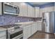 Modern kitchen featuring stainless steel appliances, white cabinets, and stylish tile backsplash at 1059 Sago Palm Ct, Mount Pleasant, SC 29429
