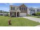 Charming two-story home with a brick facade, well-manicured lawn, and inviting front porch at 110 Levis Song Ct, Goose Creek, SC 29445