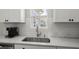 Close-up of a kitchen sink and countertop, showcasing white cabinets and subway tile backsplash at 110 Levis Song Ct, Goose Creek, SC 29445