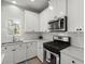 Bright kitchen with white cabinets, stainless steel appliances, and modern finishes at 110 Levis Song Ct, Goose Creek, SC 29445