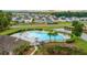 An aerial view of the community pool with abundant seating, palm trees, nearby pond, and neighborhood homes at 110 Levis Song Ct, Goose Creek, SC 29445