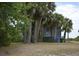 Charming home nestled amongst towering palm trees, sitting on pilings at 1106 Palmetto Blvd, Edisto Island, SC 29438