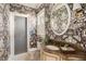 Elegant powder room with brown patterned wallpaper, marble countertop, and glass-enclosed shower at 12 Orange St, Charleston, SC 29401