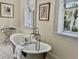 Bathroom featuring a freestanding tub, marble floors, and windows overlooking the greenery outside at 12 Orange St, Charleston, SC 29401