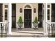 Front porch with black door, black shutters, and decorative potted plants at 12 Orange St, Charleston, SC 29401