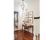 Inviting hallway features wood floors, decorative table, artwork, and a peek into a wallpapered powder room at 12 Orange St, Charleston, SC 29401