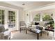 Bright living room with French doors, large arched windows, and cozy seating with elegant decor at 12 Orange St, Charleston, SC 29401