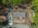Birds eye view of single-story house with gray roof surrounded by dense trees and green grass and small yard at 120 Perry Hill Rd, Moncks Corner, SC 29461