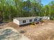 Inviting single-story home with well-kept lawn and landscaping, complete with a cozy front porch and manicured shrubbery at 120 Perry Hill Rd, Moncks Corner, SC 29461