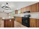 A kitchen with wood cabinets, black appliances, and an island with light countertops at 120 Perry Hill Rd, Moncks Corner, SC 29461