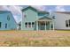 New home backyard featuring a patio and large lawn, complemented by green siding and ample space at 1238 Homecoming Blvd Blvd, Ravenel, SC 29470