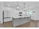A bright kitchen showcasing white cabinets, stainless steel appliances, a large island, and stylish pendant lighting at 1238 Homecoming Blvd Blvd, Ravenel, SC 29470